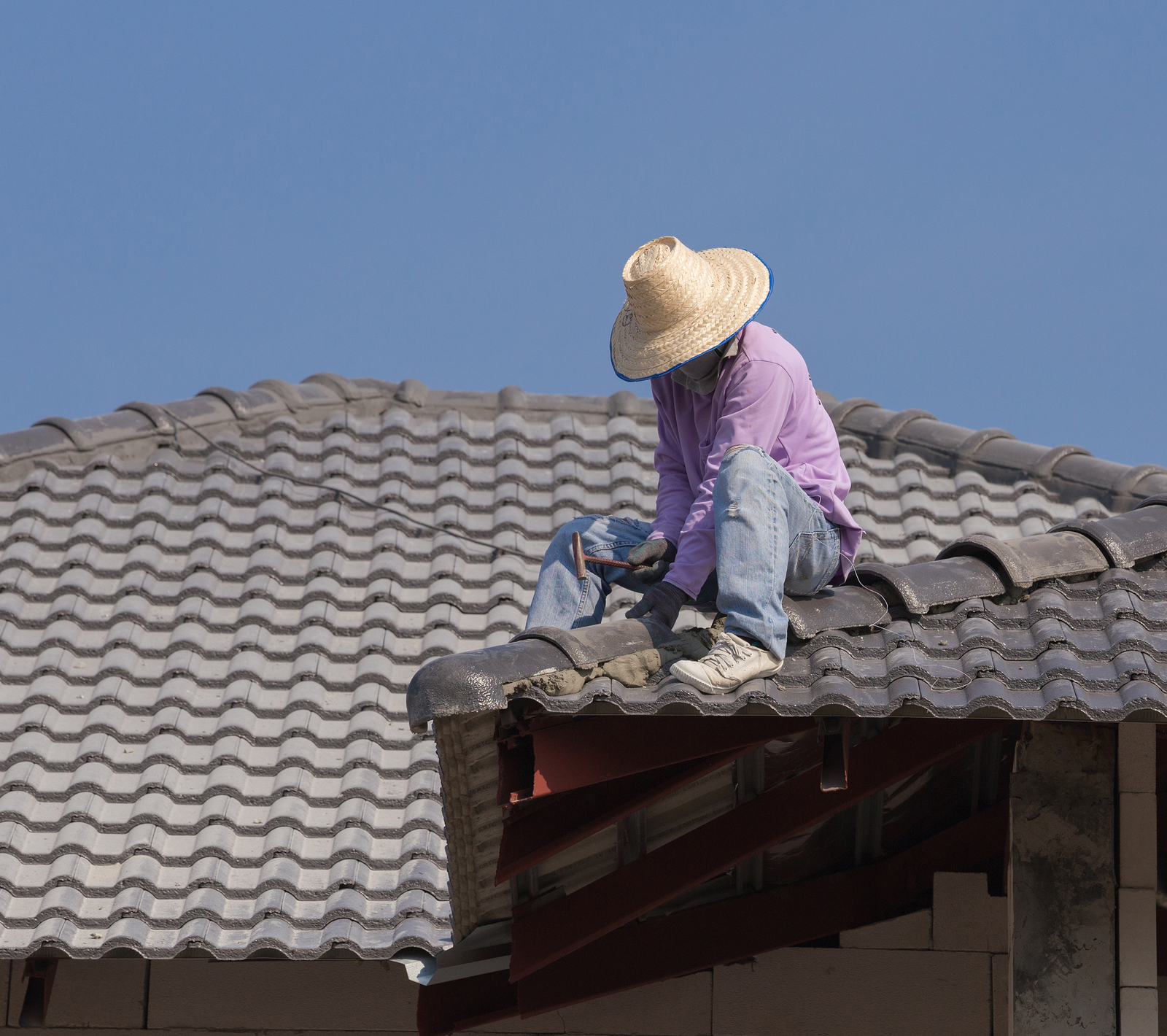 Workers Installing Roof Tiles For Home Building